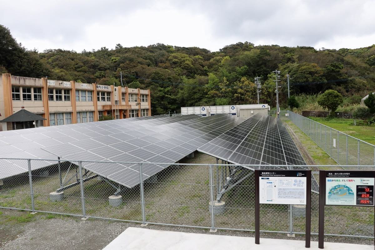 図　住友商事と薩摩川内市が共同で建設した太陽光発電システム。奥に見える物流コンテナにはEVの使い古しのリチウムイオン蓄電池が入っており、太陽光発電システムの出力変動を吸収する役目を担っている