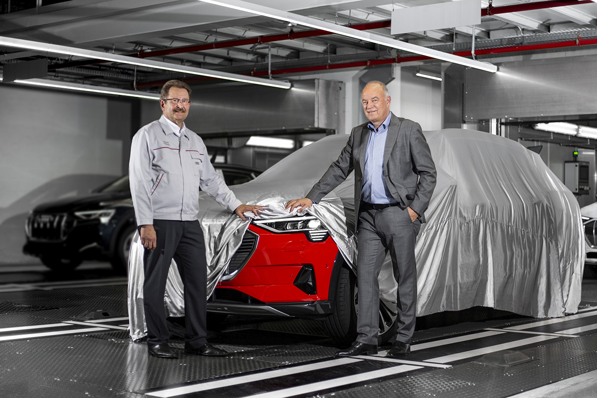 図　Audi Brusselsの取締役社長を務めるPatrick Danau氏（左）と、Audiの理事を務めるPeter Kössler氏（右）が、完成した車両にかかったベールを少しだけ引き上げて見せている