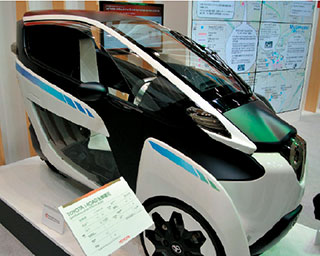 写真2　「TOYOTA i-ROAD」。都市での渋滞や駐車スペース、低炭素で持続可能な街づくりへの諸課題の解決などのニーズに応える超小型2人乗り電気自動車（EV）。