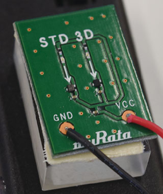 村田製作所は、磁石を近づけることにより、電力や水、ガスの使用量の記録を阻害する、いわゆる盗電や盗エネルギーからメーターを防御する3D AMR（Anisotropic Magneto-Resistance、異方性磁気抵抗）センサーを開発し、2014年9月30日より出荷している。同製品は360度からの磁力に対抗できるため、デバイス上に1つ搭載することで対応できる。大きさは1.45×1.45×0.55mmと小型になっており（写真の3D側の矢印の先の部分）、すでに中国において、工場などの大規模事業者の電力メーターへの供給を開始している。
