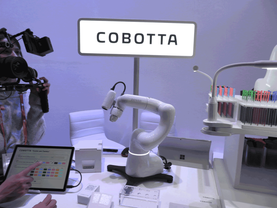 写真3　名前入りの3色ボールペンを製造する「COBOTTA」（中央）