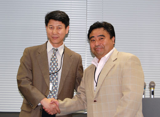 写真1　東大グリーンICTプロジェクト代表の江崎浩教授（右）と握手する、中日緑色ITプロジェクトの中国側の責任者の一人として活躍する清華大学　ニュウ（牛 志升）教授
