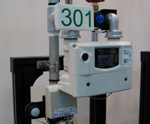 写真15　都市ガス用超音波ガスメーター（矢崎総業製）と富士電機のNCU（左下の箱）