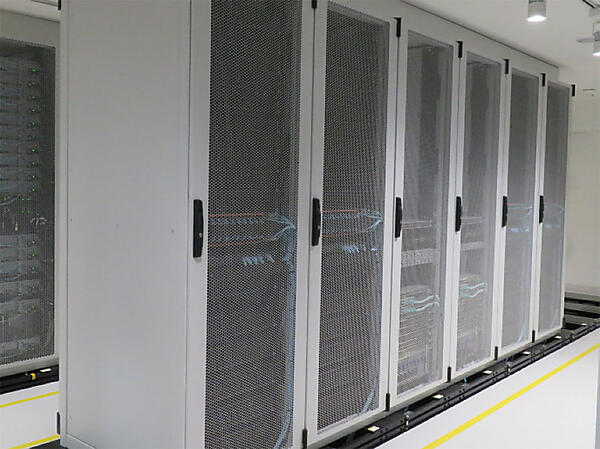 写真2　サーバルーム〔汎用サーバ（ノード）600台設置。CPUはIntel Xeonを使用〕。商用サービスで必要となるノード（RAN、伝送、EPC、IMS、BSS、OSS等）が、商用システムと同じ構成で構築されている。現時点は4G設定であるが、5Gの商用化も見据えて設計されているためソフトのアップグレードで容易に5Gへの移行が可能。