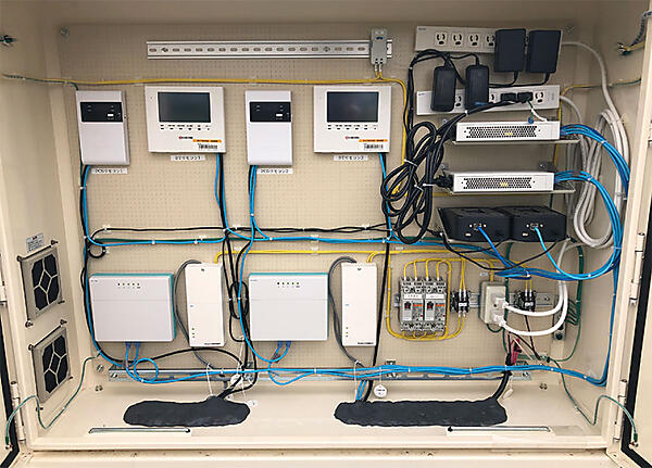 写真7　計測機器収納盤内部に設置された2台の黒い機器（右側中央の）がLO3のゲートウェイ「TAGe G2」（TransActiveGrid element 2nd Generation）