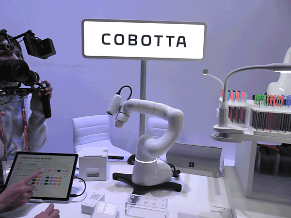 写真3　名前入りの3色ボールペンを製造する「COBOTTA」（中央）