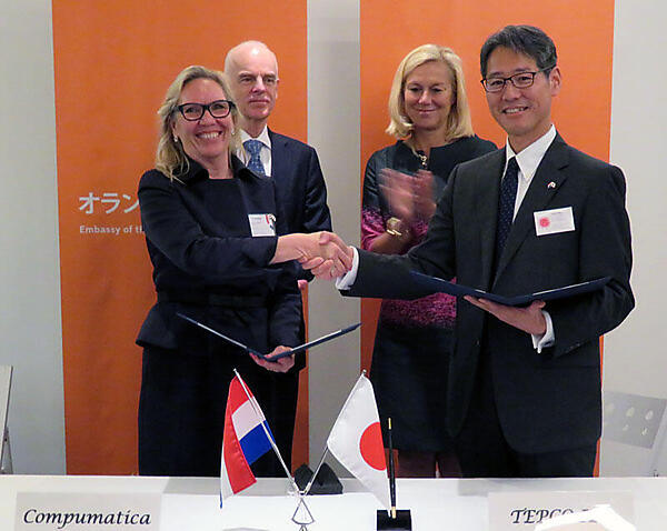 写真1　協力覚書署名を終えて握手するコンピュマティカ社CEO&Ownerのぺトラ・ヴァン・シャイク（Petra van Schayik）氏（前列左）とTEPCO IEC代表取締役社長（CEO）の大石 峰士（おおいし たかし）氏。後列は、同席したオランダ外国貿易・開発協力省大臣のシフリット・カーフ（Sigrid Kaag）氏（後列右）と駐日オランダ特命全権大使のアルト・ヤコビ（Aart Jacobi）氏（後列左）